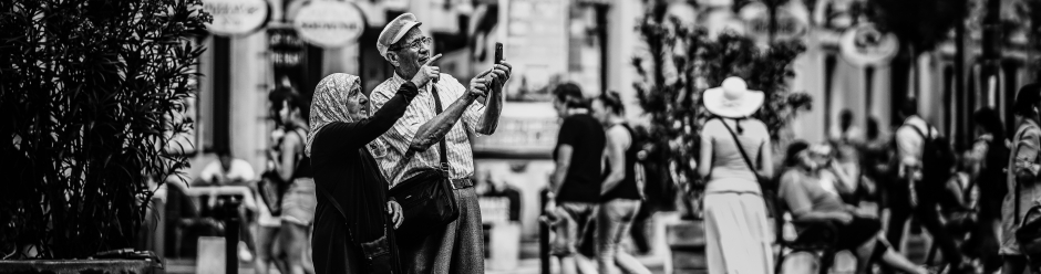 An older couple looking at a smartphone in a historic city